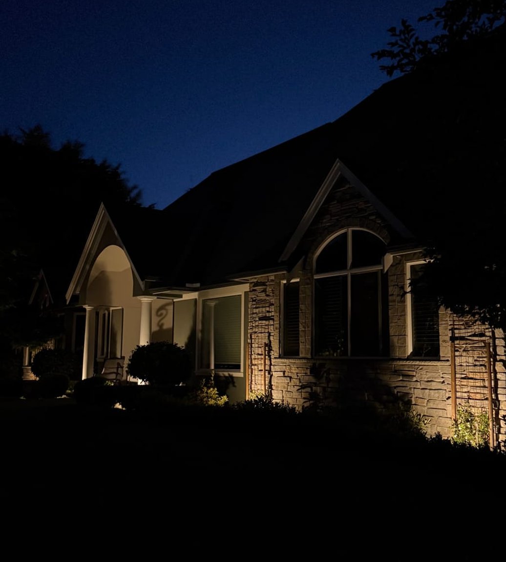 Landscape lighting on a stone home at night in Anacortes, WA